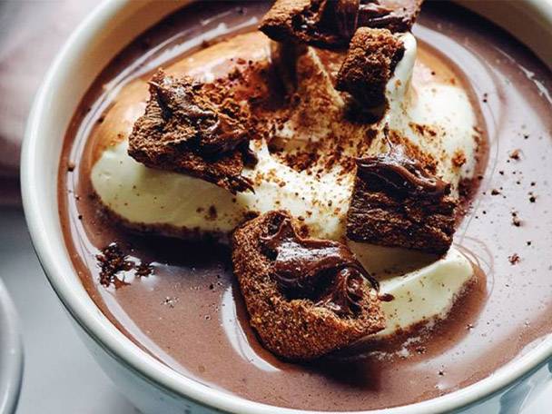 Hot chocolate with whipped cream and biscuits.