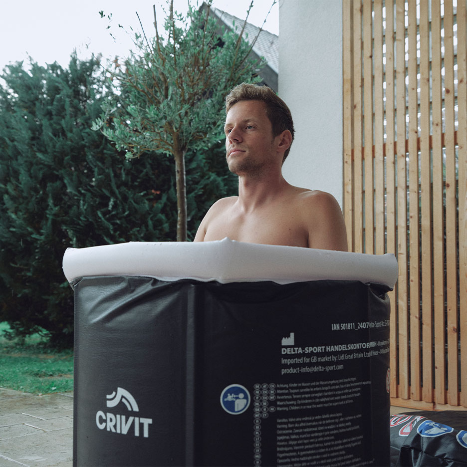 Man in Crivit ice bath outdoors.