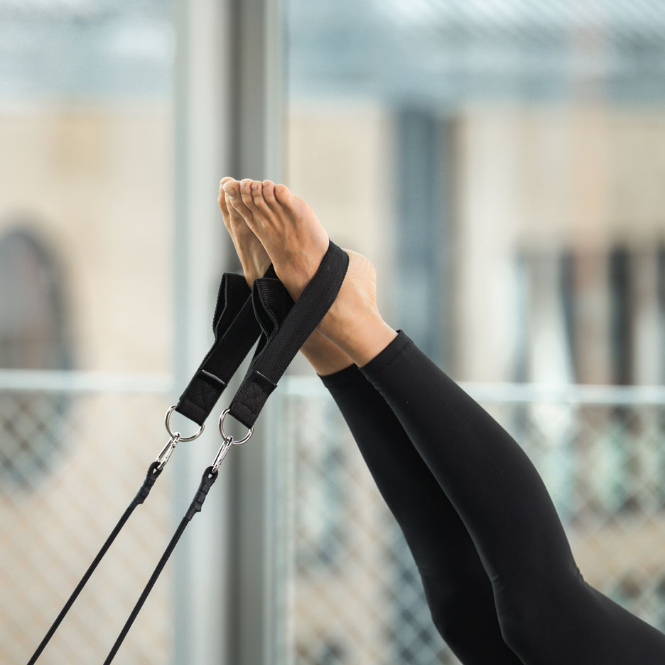 Person doing Pilates with feet in straps.