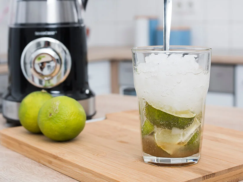 Blender and a lime drink with ice.