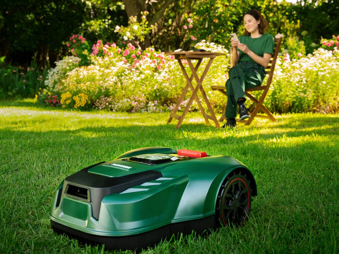Gardena robotic lawn mower in a flower garden.
