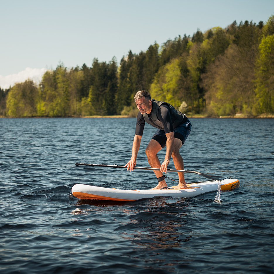 Man paddleboarding on a lake.