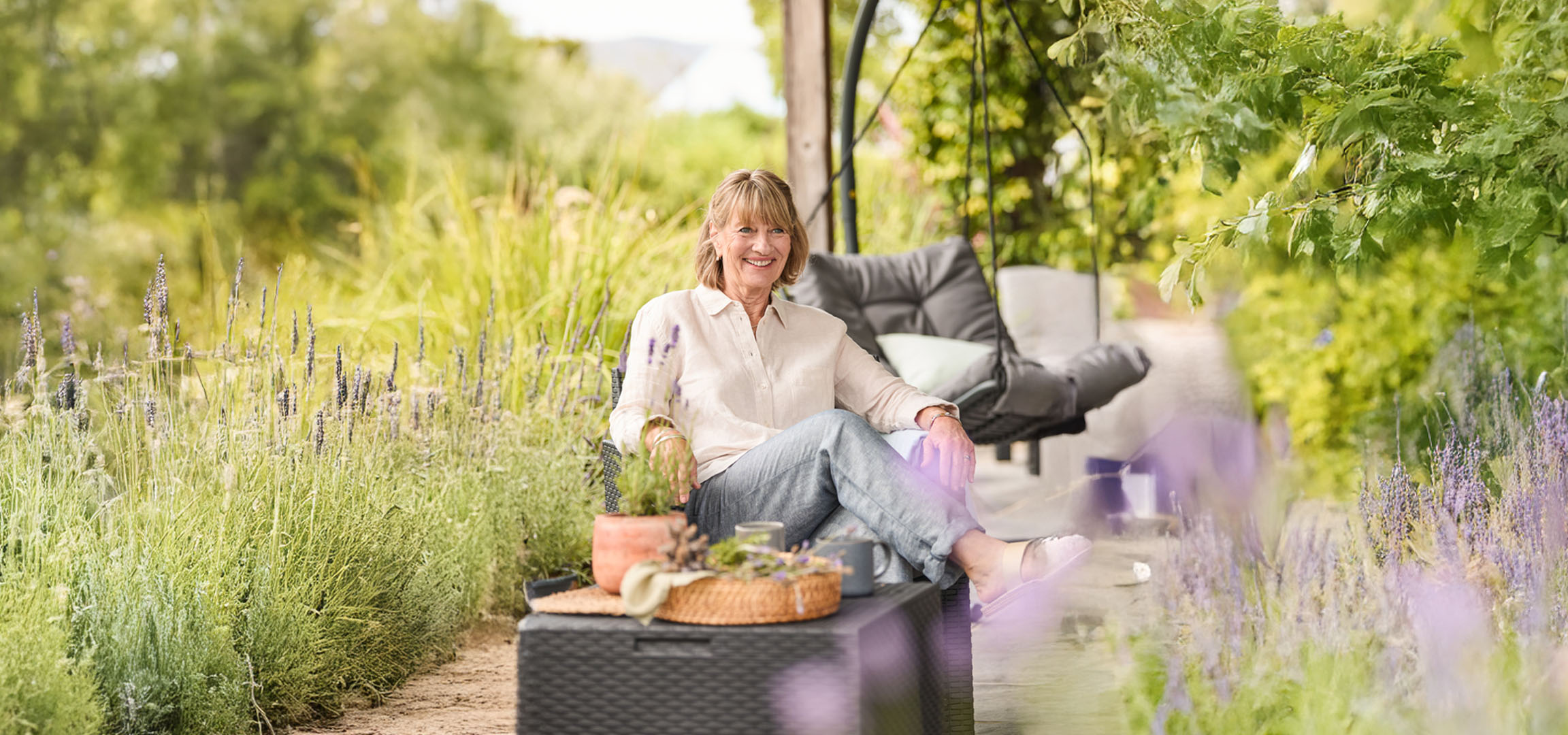 Woman relaxing outdoors with garden furniture.
