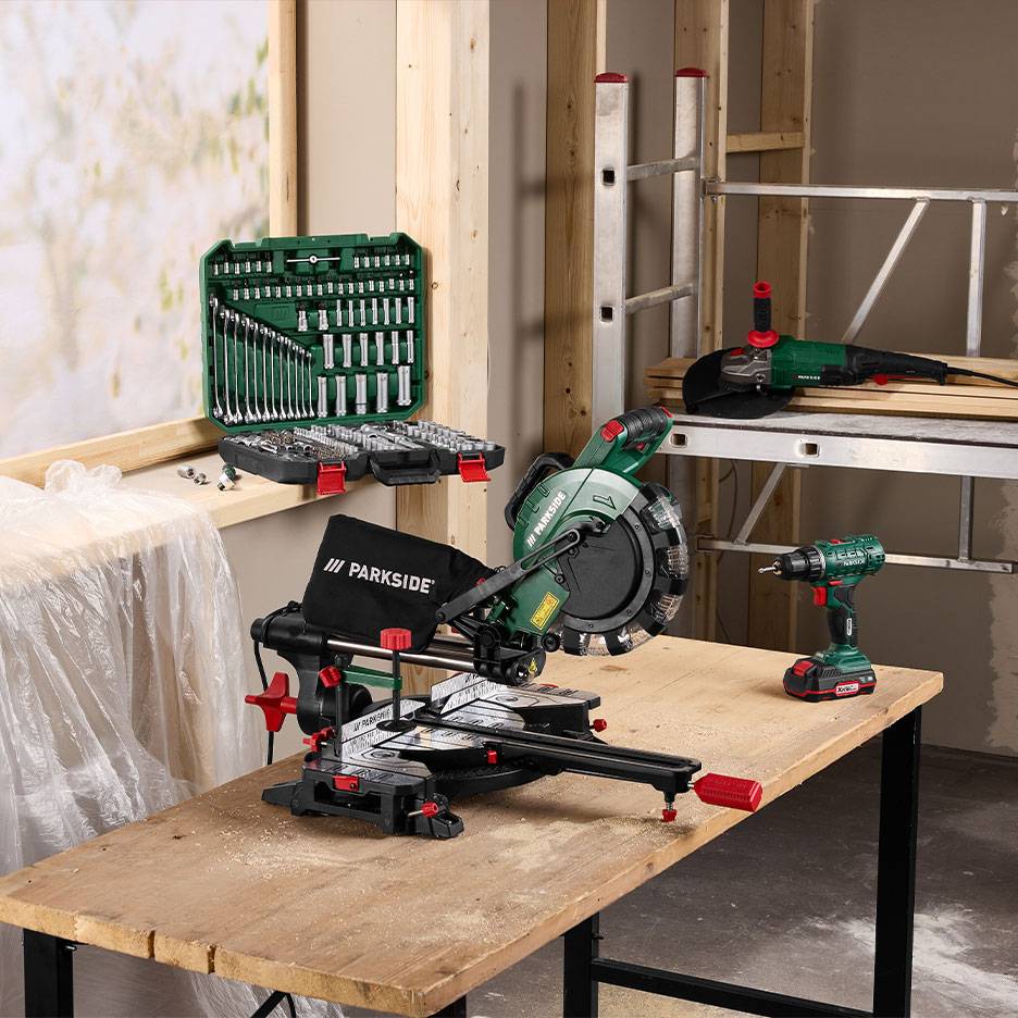 Power tools and a wrench set in a woodworking workshop.