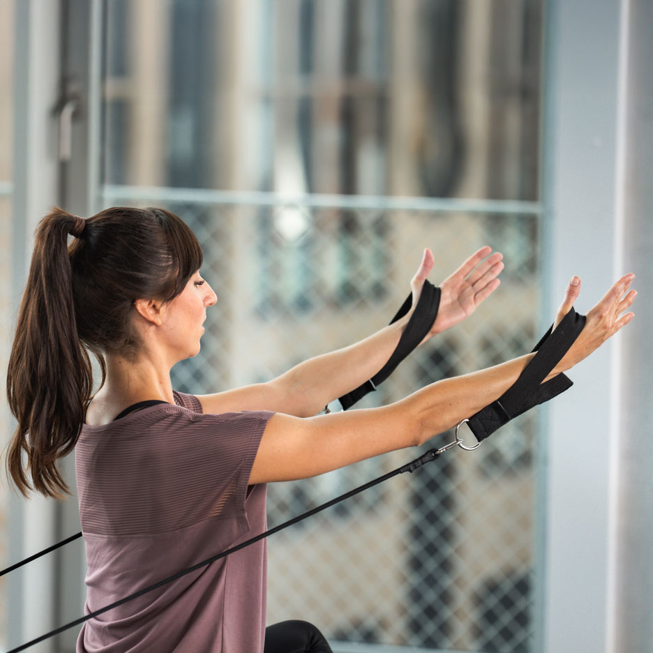 Woman exercising with resistance bands, focusing on upper body.