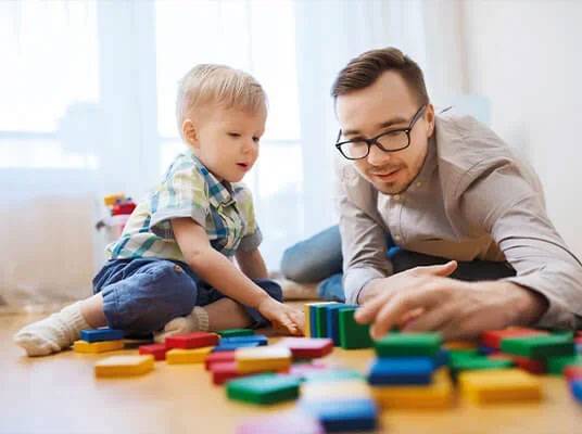 Father and son playing with wooden blocks.