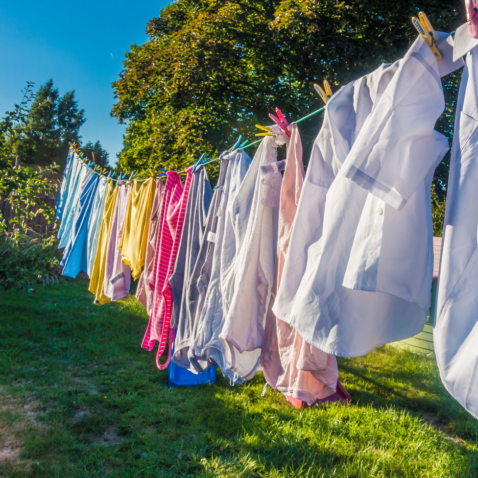Colorful clothes and shirts drying on a clothesline.